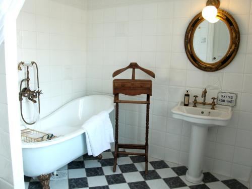 y baño con bañera y lavamanos. en Södertuna Slott en Gnesta