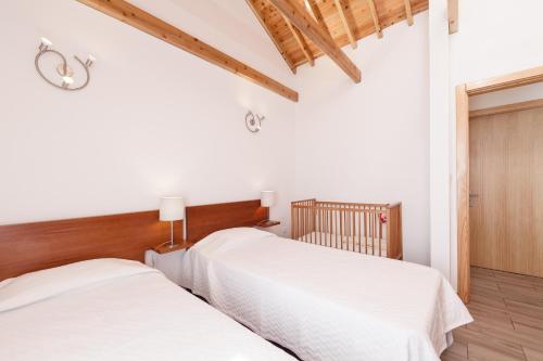 two beds in a room with white walls at Alojamentos Pontas Negras in Pontas Negras