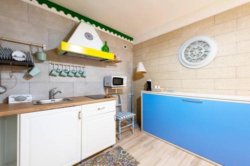 Extravacanza Porto في باري: مطبخ مع مغسلة وثلاجة زرقاء