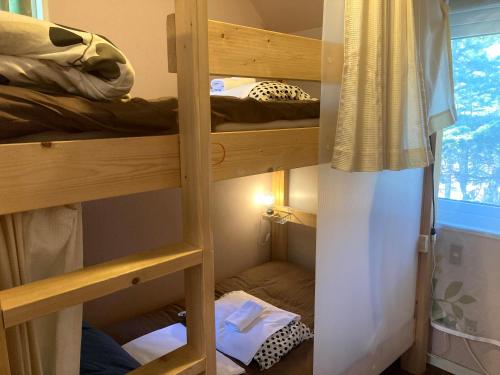 a room with two bunk beds and a window at Bellscabin Guesthouse in Karuizawa