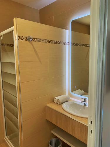 a bathroom with a sink and a mirror at Hôtel Beau Soleil in Le Lavandou