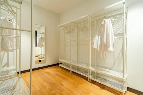 a walk in closet with glass shelves and a mirror at Edificio Fénix by Plaza Mayor Apartamentos in Valladolid