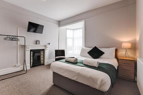 a bedroom with a large bed and a fireplace at Alexandra House in Swansea
