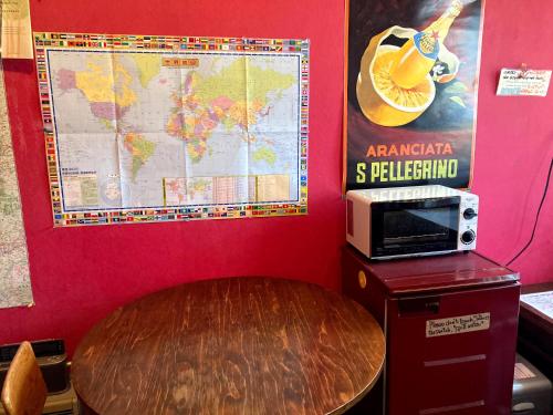 a table with a microwave and a map on a wall at Bellscabin Guesthouse in Karuizawa