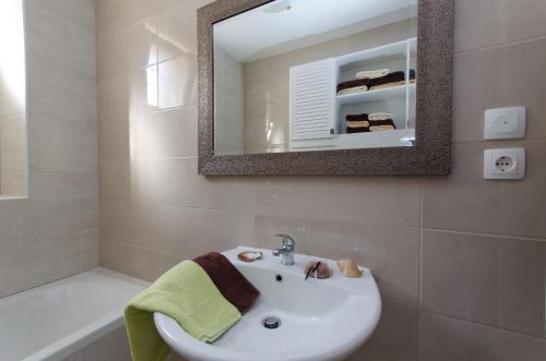 a bathroom with a sink and a mirror and a tub at DIANA in Crikvenica