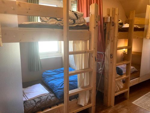 a room with two bunk beds and a window at Bellscabin Guesthouse in Karuizawa