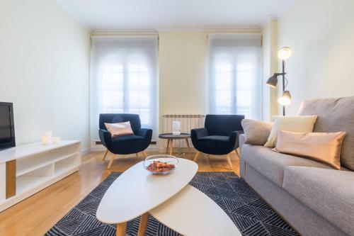 sala de estar con sofá, sillas y mesa en MIT House Retiro II en Madrid Capital, en Madrid