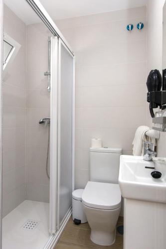 a bathroom with a shower and a toilet and a sink at Hostal La Estrella in Marbella