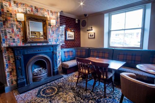 a restaurant with a fireplace and a table and a mirror at Brunel Inn in Saltash