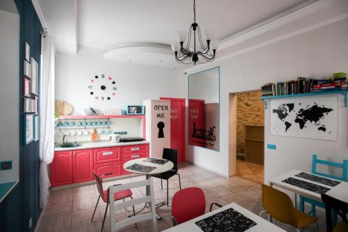 Hostel Krolichya Nora في كازان: مطبخ مع دواليب حمراء وطاولة وكراسي