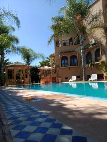 a large swimming pool in front of a building at Les Jardins de Ryad Bahia in Meknès