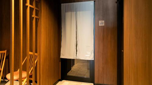 a glass door with a window in a room at KOKO HOTEL Hidatakayama - formaly Hotel Wing Hida Takayama in Takayama