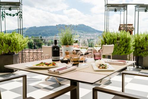 a table with plates of food and wine on a balcony at Hotel Bellevue Palace Bern in Bern