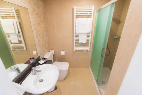 a bathroom with a sink and a toilet and a shower at Chrielka Hotel in Limassol