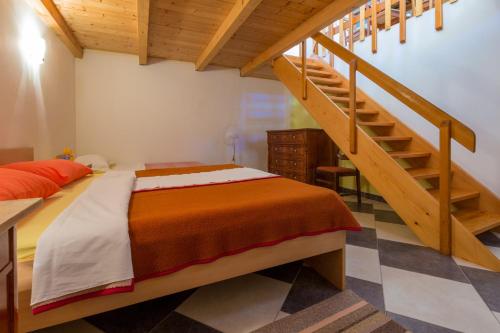 a bedroom with a bed and a wooden staircase at JELICIC C in Crikvenica