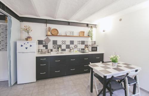 a kitchen with a table and a white refrigerator at Al Beniss in Acquaseria