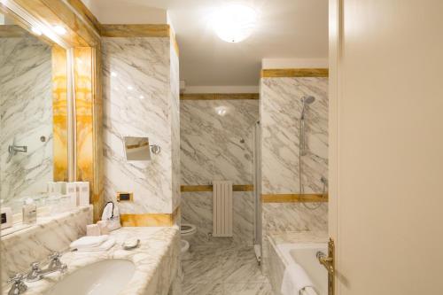 a bathroom with a tub and a sink and a shower at Imperiale Palace Hotel in Santa Margherita Ligure