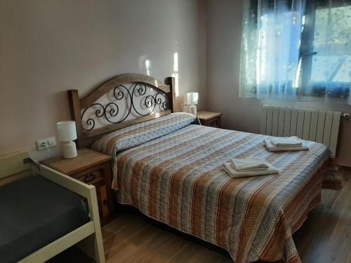 a bedroom with a bed with two towels on it at Alojamientos Rurales Hurdes Altas - La Antigua Guarderia in Casares de las Hurdes