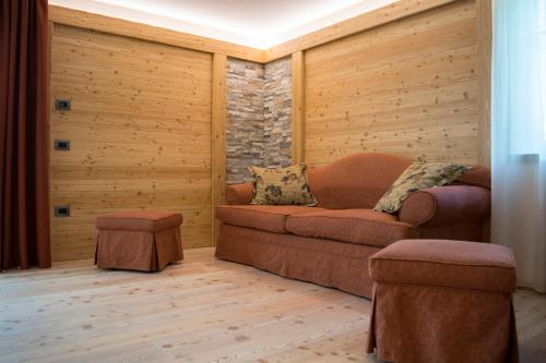 a living room with a couch and a brick wall at Alpen Garten Hotel Margherita in Rumo