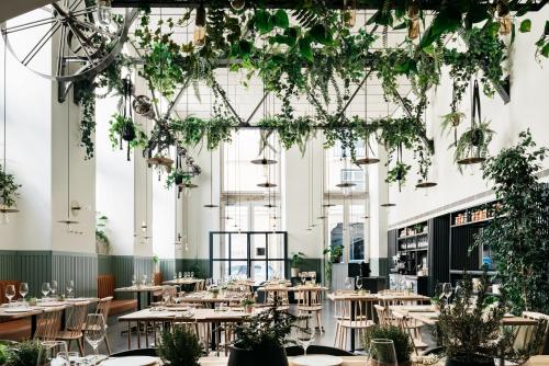 a restaurant with tables and plants hanging from the ceilings at The Lisboans Apartments in Lisbon