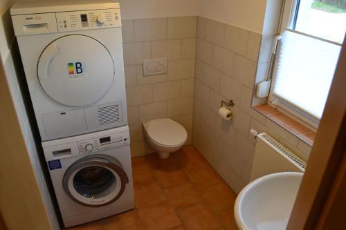 a bathroom with a washing machine and a toilet at An der Kapf in Münsingen
