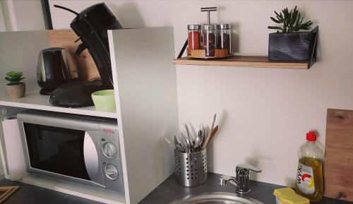 a kitchen counter with a sink and a microwave at Studio Confort Netflix Business in Brétigny-sur-Orge