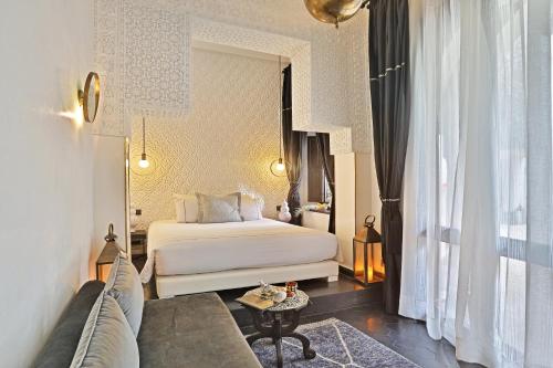a hotel room with a bed and a couch at Dar Kandi in Marrakech