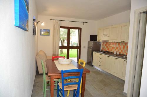 uma cozinha com mesa e cadeiras num quarto em Oleandro em Lotzorai