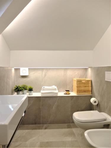 a bathroom with a white toilet and a sink at La Spiaggia in Oliveto Lario