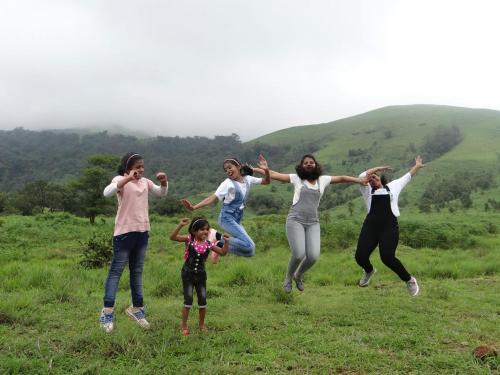 a group of women jumping in a field at Vamoose Prince of Kalasa in Kalasa