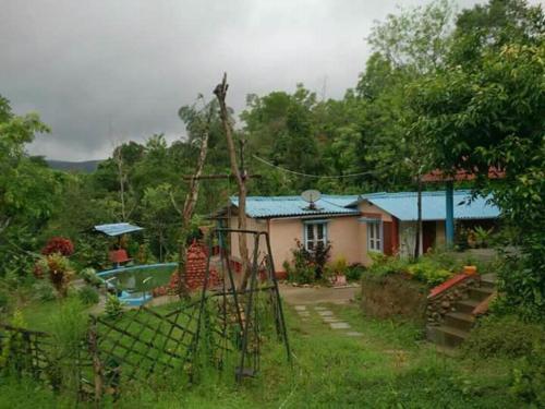 a house with a fence in front of a yard at Vamoose Prince of Kalasa in Kalasa