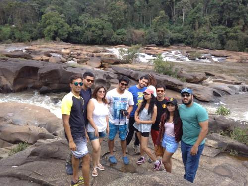 a group of people standing on rocks near a river at Vamoose Prince of Kalasa in Kalasa