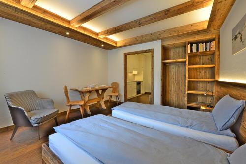 a bedroom with a bed and a table and chairs at Chesa Madrisa in St. Moritz