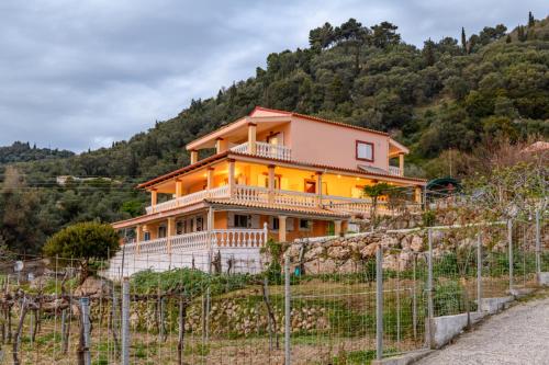 a house on a hill behind a fence at Tolis aparts in Pelekas