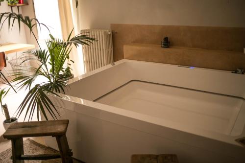 a bath tub in a room with a chair and a plant at 4 Balconi rooms-Boutique B&B in Lecce