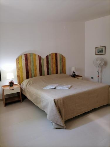 a bedroom with a large bed with a headboard at Alloggi Estivi D & A in Taranto