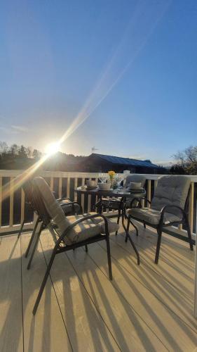 a deck with three chairs and a table on a balcony at Livvi Rosa's Lodge in Newton on the Moor
