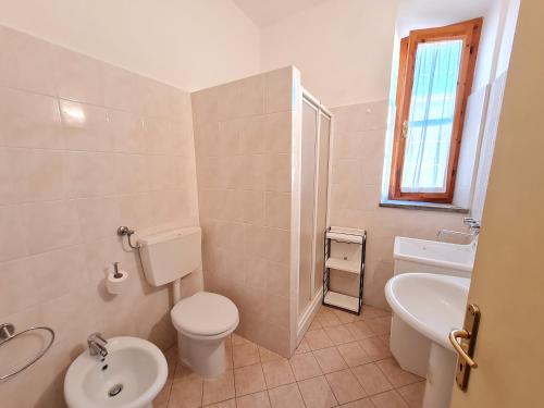 a white bathroom with a toilet and a sink at Agriturismo Buonavista - Parco della Maremma in Alberese