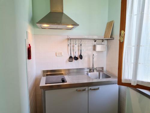 a small kitchen with a sink and a stove at Agriturismo Buonavista - Parco della Maremma in Alberese