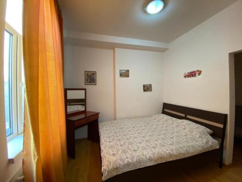 a bedroom with a bed and a table and a window at Budget Inn Amzei in Bucharest