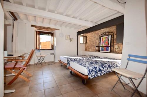 een slaapkamer met 2 bedden en een tafel en stoelen bij IL NIDO in Campiglia Marittima