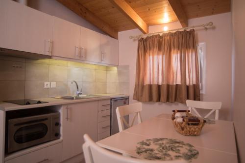 a kitchen with a table and chairs and a sink at Studios Artemis in Lefkada Town