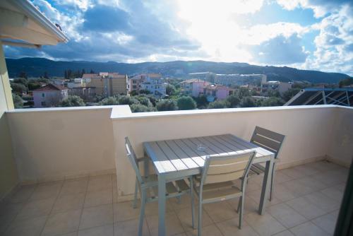 a table and chairs on a balcony with a view at Studios Artemis in Lefkada Town