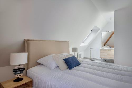 une chambre avec un grand lit blanc et un escalier dans l'établissement Appartement pour 6 à 50m de la plage, à Pléneuf-Val-André