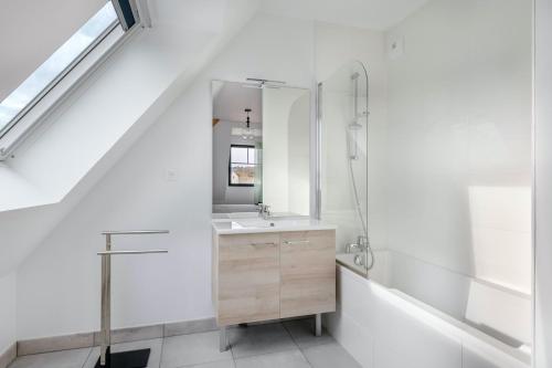 une salle de bain avec un lavabo et un miroir dans l'établissement Appartement pour 6 à 50m de la plage, à Pléneuf-Val-André