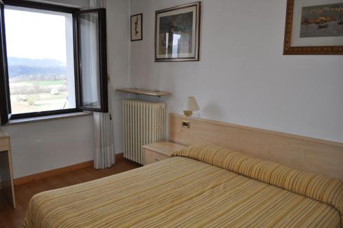a bedroom with a bed and a window at Hotel Piol in Limana