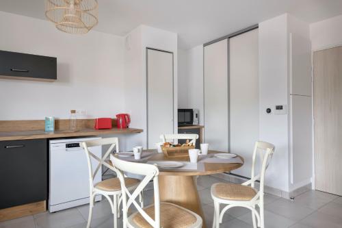 une cuisine avec une table et des chaises dans une pièce dans l'établissement Appartement en bord de mer à Pléneuf-Val-André, à Pléneuf-Val-André