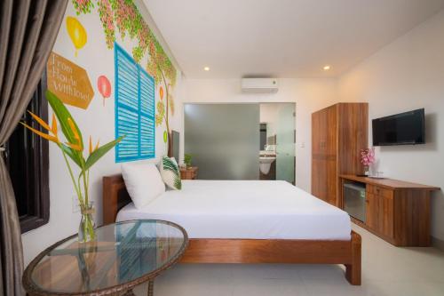 a bedroom with a bed and a glass table at Spring Garden Villa Hoi An in Hoi An