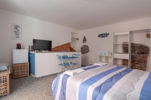 a bedroom with a blue and white bed and a refrigerator at Ludovica Flat in Vernazza