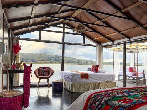 a bedroom with two beds and a view of the water at Amalia Titicaca Lodge in Puno
